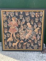Full framed tapestry showing a medieval pastoral scene with a man and woman with sheep and spindle surrounded by floral patterns, custom wood frame.
