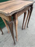 Close up of decorative carved edge and cabriole legs of the nested tables