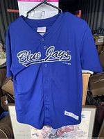Front view of blue button-up Toronto Blue Jays jersey showing Blue Jays script logo.
