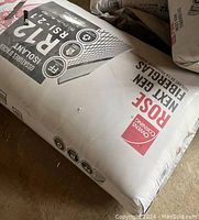 Photo of a new packaged Owens Corning R12 fiberglass insulation roll on the floor.