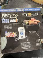 Box front showing BBQCroc Cool Grill branding and details: cooler holds food, drinks, and also includes the grill for cooking up to four items.