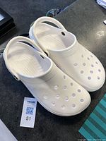 Top side view of the white Crocs showing ventilation holes and adjustable heel strap