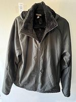 Front view of the men's black winter coat with zipper and soft inner lining visible