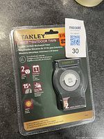 Front view of new Stanley TimeIt Outdoor Twin 24-hour mechanical timer in original sealed packaging showing timer dial, plug, and outlets.