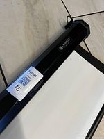 Close-up of the Quartet projector screen showing the black casing with the Quartet logo and material edge.