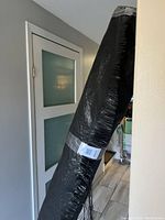 Photo of the roll of black weed fabric, showing the tightly rolled material taped for storage.