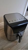Air fryer showing overall unit with stainless steel and black plastic design.