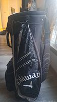 Photo showing side profile of the Callaway golf bag with visible logo, zipped pockets and shoulder strap.