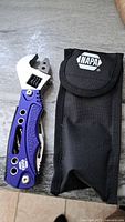 Image showing Napa multi tool with blue handle and adjustable wrench, next to black carrying case with Napa logo.