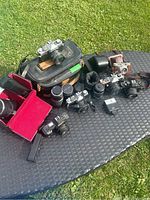 Overview of all six cameras, two zoom lenses and cases on outdoor table