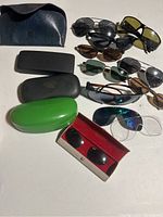 Overview showing all sunglasses and cases, illustrating variety and condition