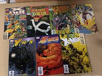 Photo showing 7 X-Men comics with colorful covers and various characters including Wolverine, Cyclops, and others.