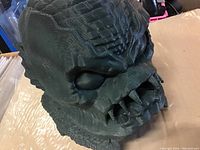 Close-up detail of dark green resin Creature from the Black Lagoon head showing textured skin, prominent ridges, and teeth.