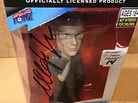 Front view of the Dexter bobblehead in sealed box showing actor signature on clear window and character holding knife.