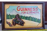 Front view of the wooden framed Guinness advertisement sign with 3D figures and colorful painted background