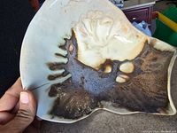 Close-up of the interior glazed surface showing brown and beige glaze pattern on the organic moss-like surface of the centerpiece.