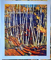 Front view of the art print showing a forest scene with white birch trees, autumn leaves in orange and yellow, rocks in the foreground, and a blue lake in the background. Bottom margin shows title and artist's name.