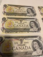 Three of the bills stacked showing sequential serial numbers and Queen Elizabeth II portrait.