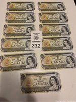 Full view of 11 sequential 1973 Canadian one dollar bills arranged in rows on white background with placard.