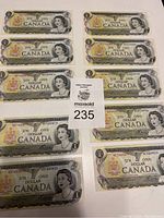 Overview of 10 Canadian $1 bills from 1973, series NB, showing front side with Queen Elizabeth II portrait and coat of arms.