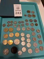 Full lot arranged on teal tray includes various Canadian coins arranged in rows alongside a blue coin book