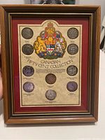 Overall view of framed display showing central coat of arms and mounted coins