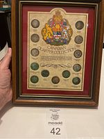 Full view of the framed Canadian Quarter Collection showing the 12 quarters and the decorative mat with Coat of Arms and text.