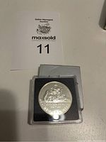 Front view of the Canada Davis Strait commemorative dollar coin in protective casing with auction label in background.