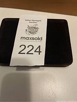 Black presentation box with MaxSold auction tag 224