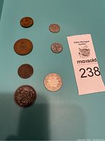 Six old Canadian coins on a blue background along with auction lot number card.
