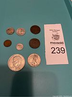 Shows the entire lot of eight US coins, various sizes and designs including silver-toned and bronze-toned coins.