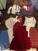 Overhead view of shirts, dress, skirts, wreath, belts on floor