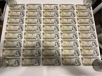 Entire uncut sheet of 40 one-dollar bills laid flat, showing full 8×5 configuration