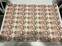 Full uncut sheet showing 8 rows of 5 two-dollar bills laid flat