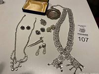 Full lot of vintage silver jewelry showing necklaces, earrings, brooch, and tray