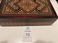 Closed wooden decorative box with detailed geometric inlay pattern on the top and sides.