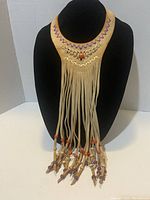 Front view of tan leather fringe choker necklace with purple and orange bead details on jewelry display stand