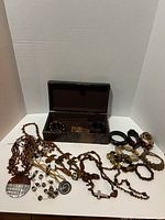 Overview of all costume jewelry items spread out with a decorative storage box to show variety and condition.