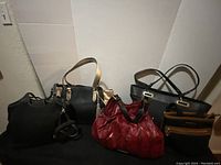 Five assorted handbags including G.I.L.I., DKNY, The Sak, Nine West, and Michael Kors.