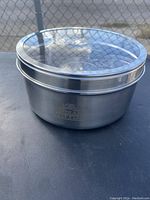 Closed view of the stainless steel spice box with clear lid showing logo on side