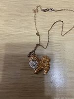 Top view of Pomeranian dog-shaped crystal pendant showing detail and chain.