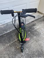 Front angle view of Razor Power Core E90 electric scooter showing black and green color scheme, foam grips, and details of handlebars and brake lever.