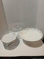 Photo shows the clear glass swirl cake stand, the milk glass lattice pedestal dessert stand, and the quilted vinyl cover containing saucer plates.