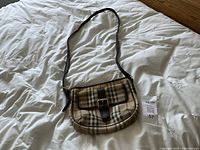 Front view of Burberry Ganton crossbody purse showing Haymarket check pattern and leather buckle pocket