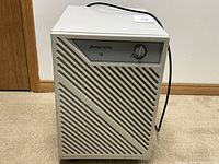 Front view of white Simplicity 15 dehumidifier showing front vent design, brand label, and control knob.