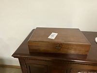 Closed wooden display case containing cutlery set