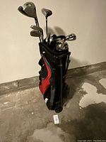 Full view of Wilson golf bag filled with golf clubs, showing multiple club heads visible and the side profile of the bag