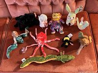 Photo showing full collection of the 10 Ty Exotic Animal Beanie Babies arranged on a couch with all tags visible.