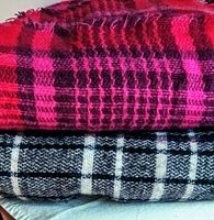 Photo of two folded hand-loomed large lightweight shawls/scarves, one in red and magenta checkered pattern, the other in black and white checkered pattern.