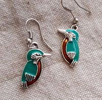 Photo shows front view of hummingbird earrings with teal and brown enamel on silver.